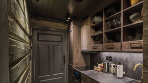 Una cucina con mobili in legno, forno a incasso, lavello e un piano di lavoro con diversi oggetti.