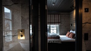 Una camera da letto con un letto, una finestra e un pavimento in legno.