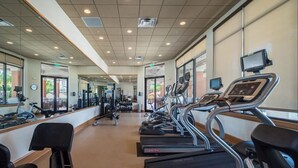 Una palestra con diverse tapis roulant, cyclette e macchinari per pesi.