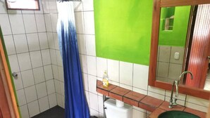 A bathroom with a shower, toilet, sink, and a mirror.