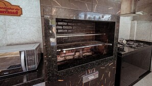 A kitchen with a built-in oven, a microwave, and a sign indicating a restaurant. - Casa c 5 su tes Piscina Churrasqueira e Sinuca (Cabedelo)