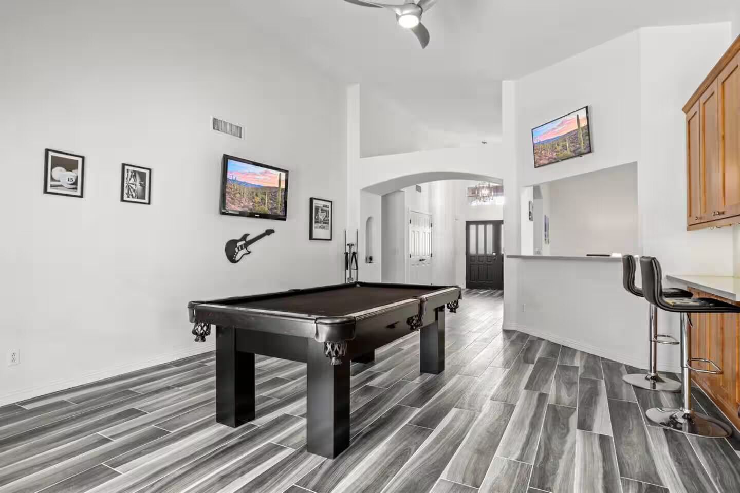 Un salon moderne doté d’une table de billard, d’un coin bar et d’un espace repas.