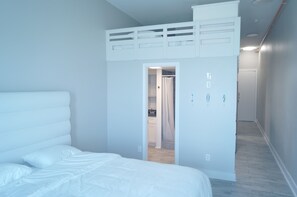 A bedroom with a bunk bed, a walk-in closet, and a hallway. - Casa Dora Sandcastle: Beachfront Fun & Loft Living (Bolivar Peninsula)