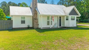 A single-story house with a chimney, a front porch, and a small attached garage. - Private Pool • 3BR Family Fun Home w/ Gazebo (Crestview)