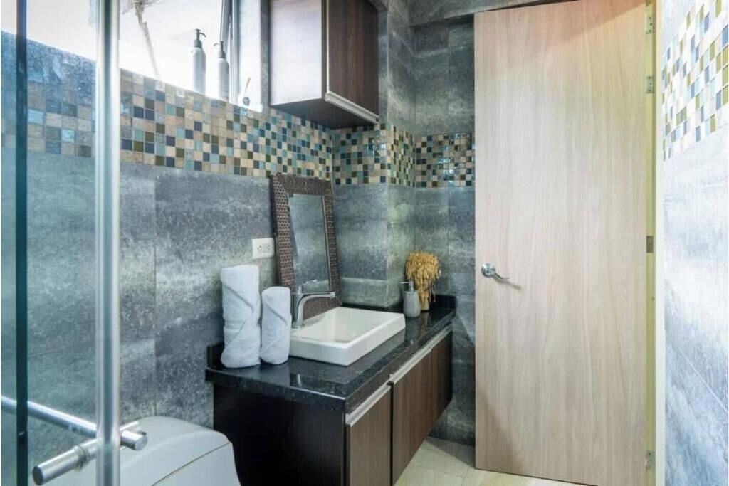 A bathroom with a sink, mirror, and toilet.