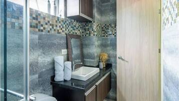 A bathroom with a sink, mirror, and toilet.