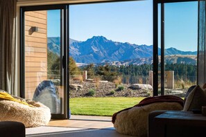A modern interior with a large sliding glass door leading to a mountain view.