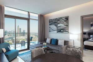 A modern hotel room with a large balcony, a sofa set, a dining table, and a bed. - Damac Maison Aykon City Dubai (Dubai)