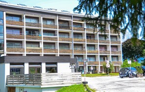 A multi-story building with a modern design, featuring balconies with wooden railings and large windows. - 2 bedroom gorgeous apartment in Ellmau (Ellmau)