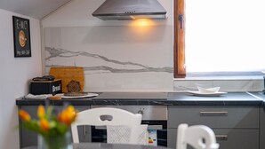 A modern kitchen with a marble backsplash, a built-in oven, and a window with a view. - Stunning home in Slatinski Drenovac (Slatinski Drenovac)