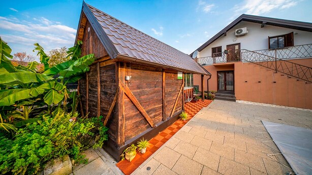 A modern house with a wooden exterior and a sloped roof, a paved courtyard, and a small garden area. - Stunning home in Slatinski Drenovac (Slatinski Drenovac)