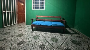 A room with green walls, a wooden door, a window, and a patterned floor. - Cozy "LORITO" Apartment at MANUEL ANTONIO / 4 People (Quepos)