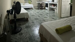 A compact hotel room with two beds, a desk, and a kitchenette. - Cozy "LORITO" Apartment at MANUEL ANTONIO / 4 People (Quepos)