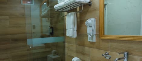 Un bagno moderno con doccia vetrata, un water bianco, un lavandino con specchio e un porta asciugamani.