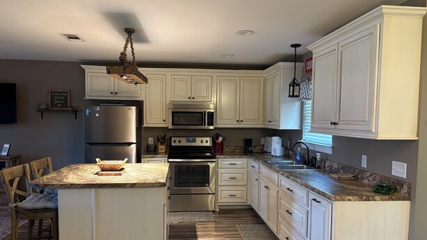A kitchen with white cabinets, stainless steel appliances, and a granite countertop. - The Cottage at The Stables - Charming 1 bedroom - Sleeps 5 (Vancleave)