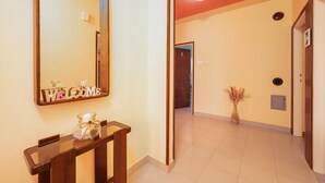 A hallway with a wooden console table, a 'WELCOME' sign, a vase with dried flowers, and a door leading to another room. - Cozy home in Sveti Bartol (Sveti Bartol)