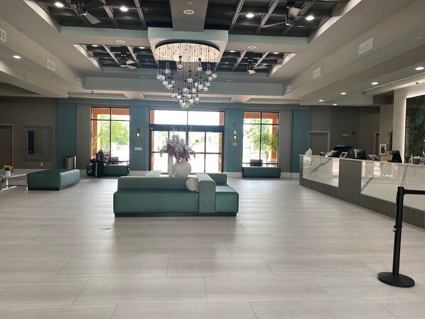 A spacious lobby with a central seating area, a reception desk, and a large chandelier. - Near Universal studios, Scenic Pool Balcony, no resort fee, shuttle option. (Orlando)