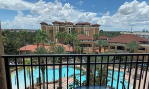 A hotel with multiple buildings, a swimming pool, and palm trees. - Near Universal studios, Scenic Pool Balcony, no resort fee, shuttle option. (Orlando)