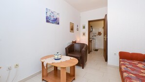 A compact living space with a dining area, a brown leather chair, a small table with a decorative item, and a sofa. - 1 bedroom nice apartment in Artatore (Artatore)