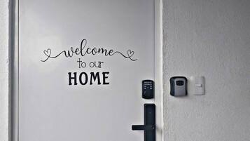 A door with a welcome sign and a keypad lock.