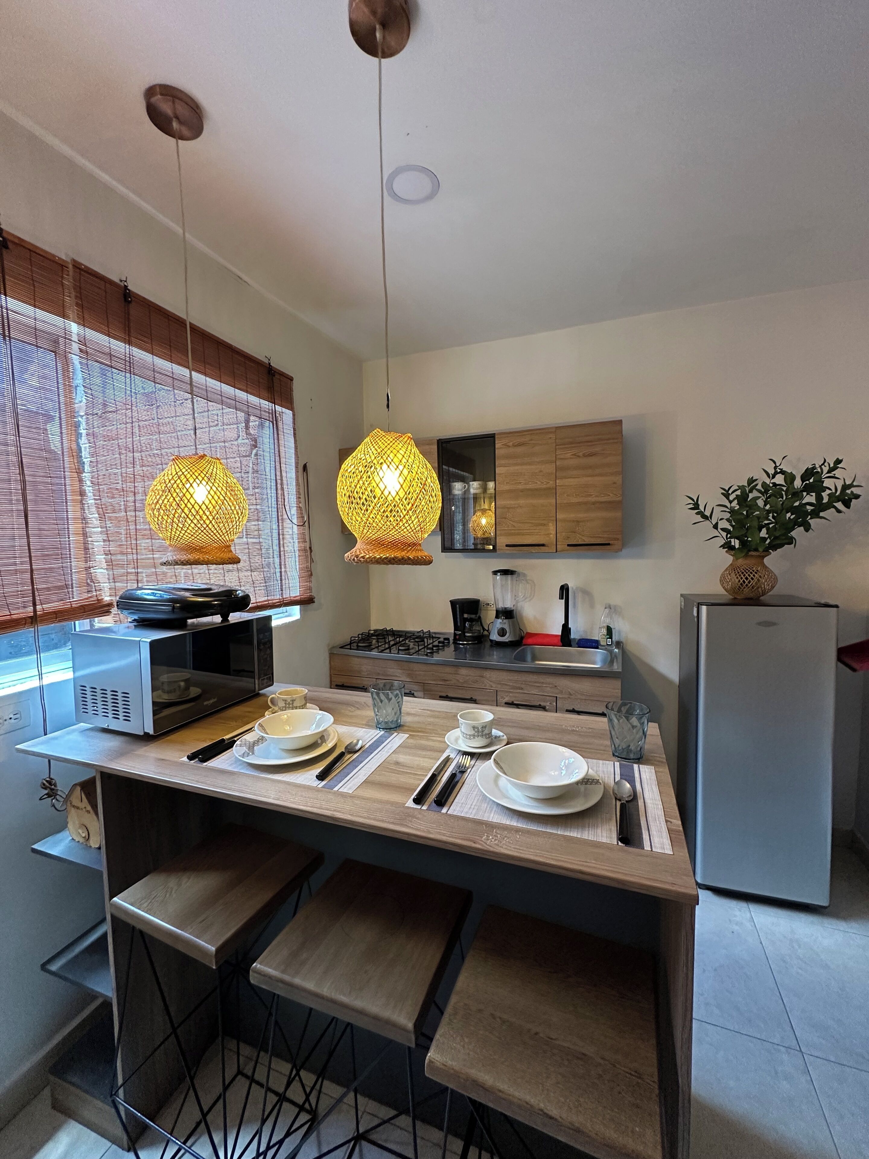 Een moderne keuken met een centraal eiland, houten kastjes en een ingebouwde magnetron.