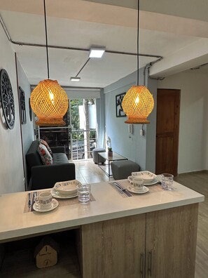 A modern kitchen with a central island, pendant lights, and a view to the outside. - APARTA HOTEL PROVENZA (Medellin)