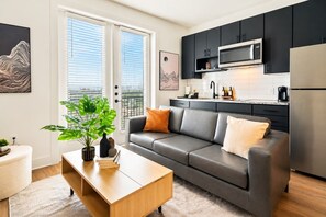 Un salon moderne avec un canapé gris, une table basse en bois et une plante en pot.