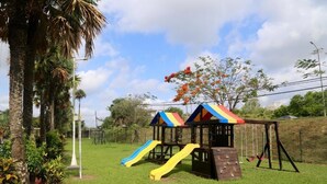 A playground with two slides and a swing set.
