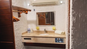 A bathroom with a sink, mirror, towel, and a hanging rack.