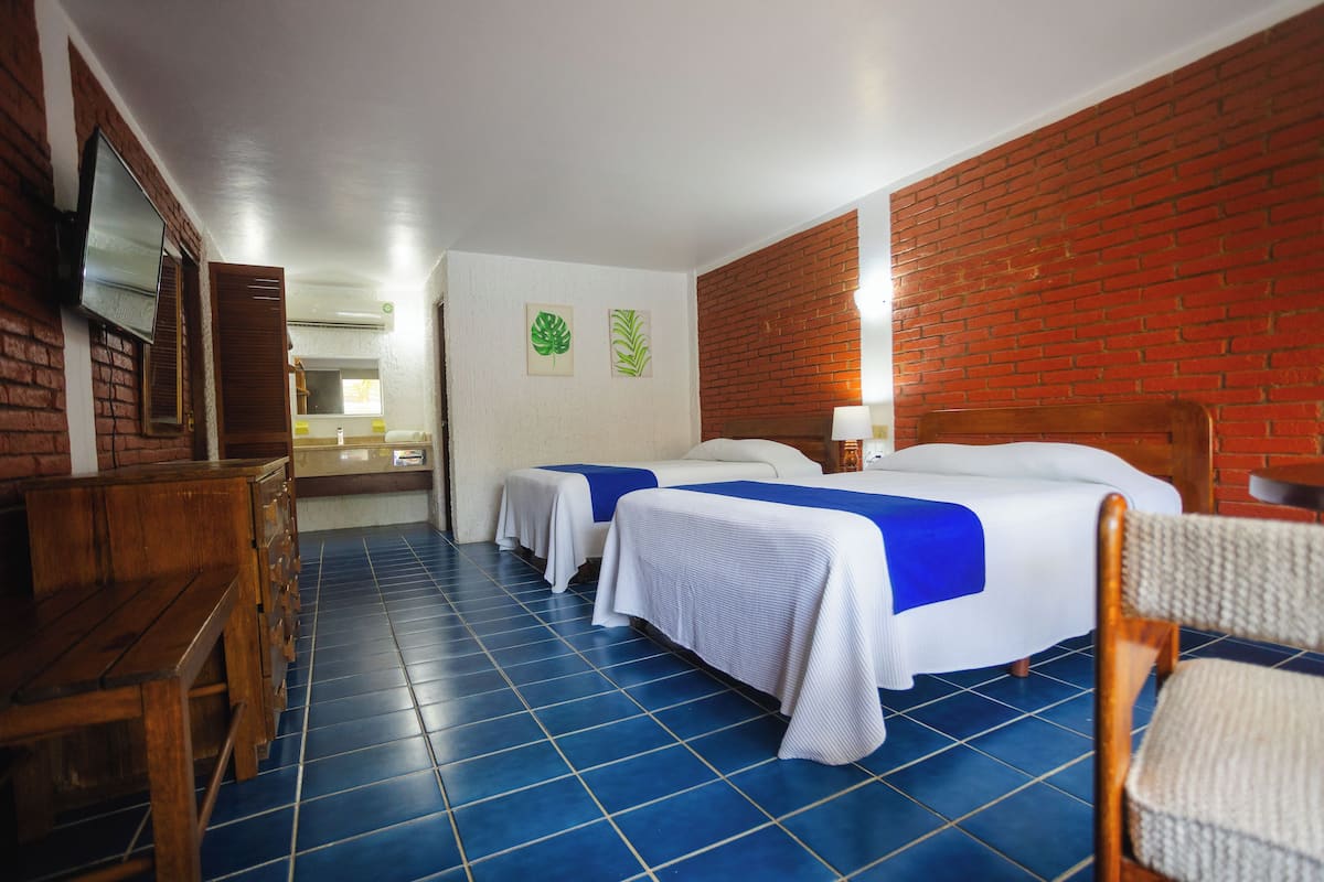 Quarto quádruplo standard, 2 camas de casal, ar-condicionado, vista para o pátio | Cofres nos quartos, ferros/tábuas de passar roupa, Wi-Fi de cortesia