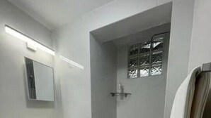 A bathroom with a toilet, sink, and shower area.