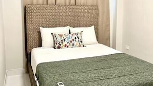 A bedroom with a bed, a headboard, and an air conditioning unit.