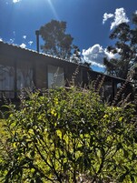 A building with a corrugated metal roof, a chimney, and a fence.