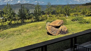 Vue depuis un espace extérieur abrité, doté d’une terrasse en bois, d’une table et de chaises.