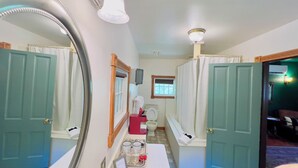 A bathroom with a large mirror, a toilet, a sink, and a window.
