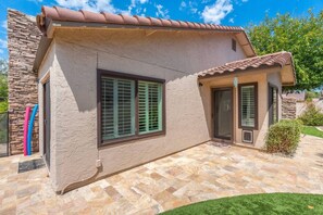 A house with a stone facade, large windows with shutters, and a tiled roof. - Sun, Fun & a Tempe Tan Home (Tempe)