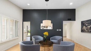 A modern living room with grey sofas, a coffee table, and a hanging light fixture. - Sun, Fun & a Tempe Tan Home (Tempe)