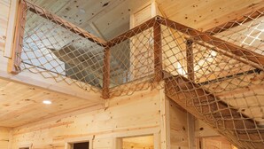 A wooden cabin interior with a netted balcony.