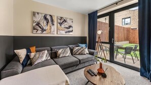 Un salón moderno con un sofá gris, una mesa de centro redonda y arte abstracto en la pared.