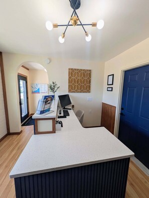 A reception desk with a computer, a map, and a decorative wall piece.