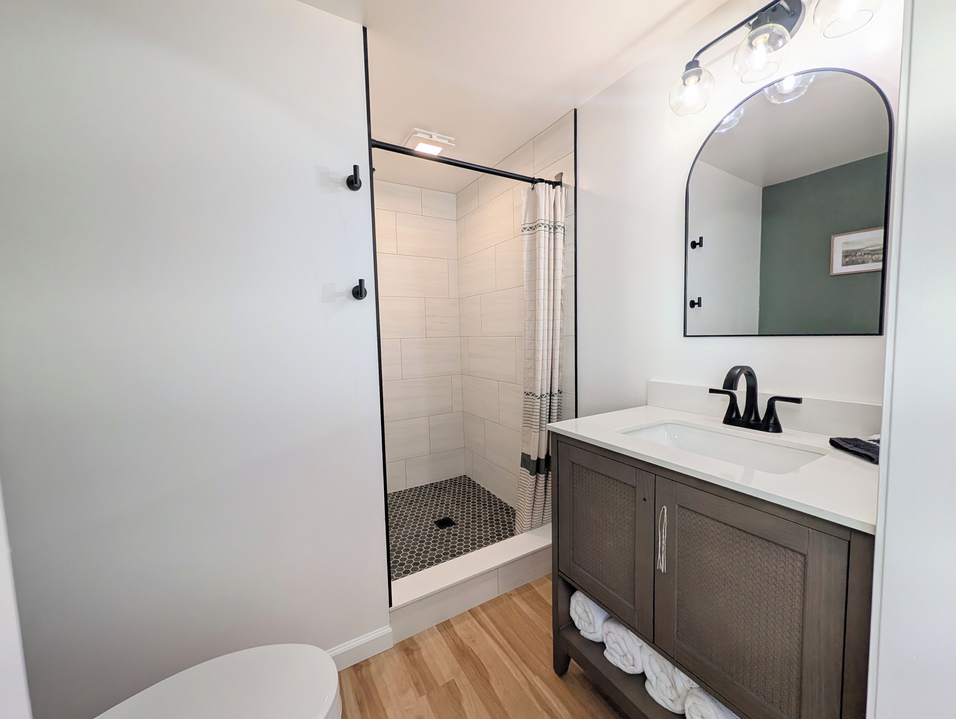 Un baño moderno con ducha, inodoro y tocador.
