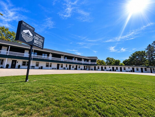 A motel with a sign indicating no vacancies, a two-story building with a flat roof, and a large parking area.
