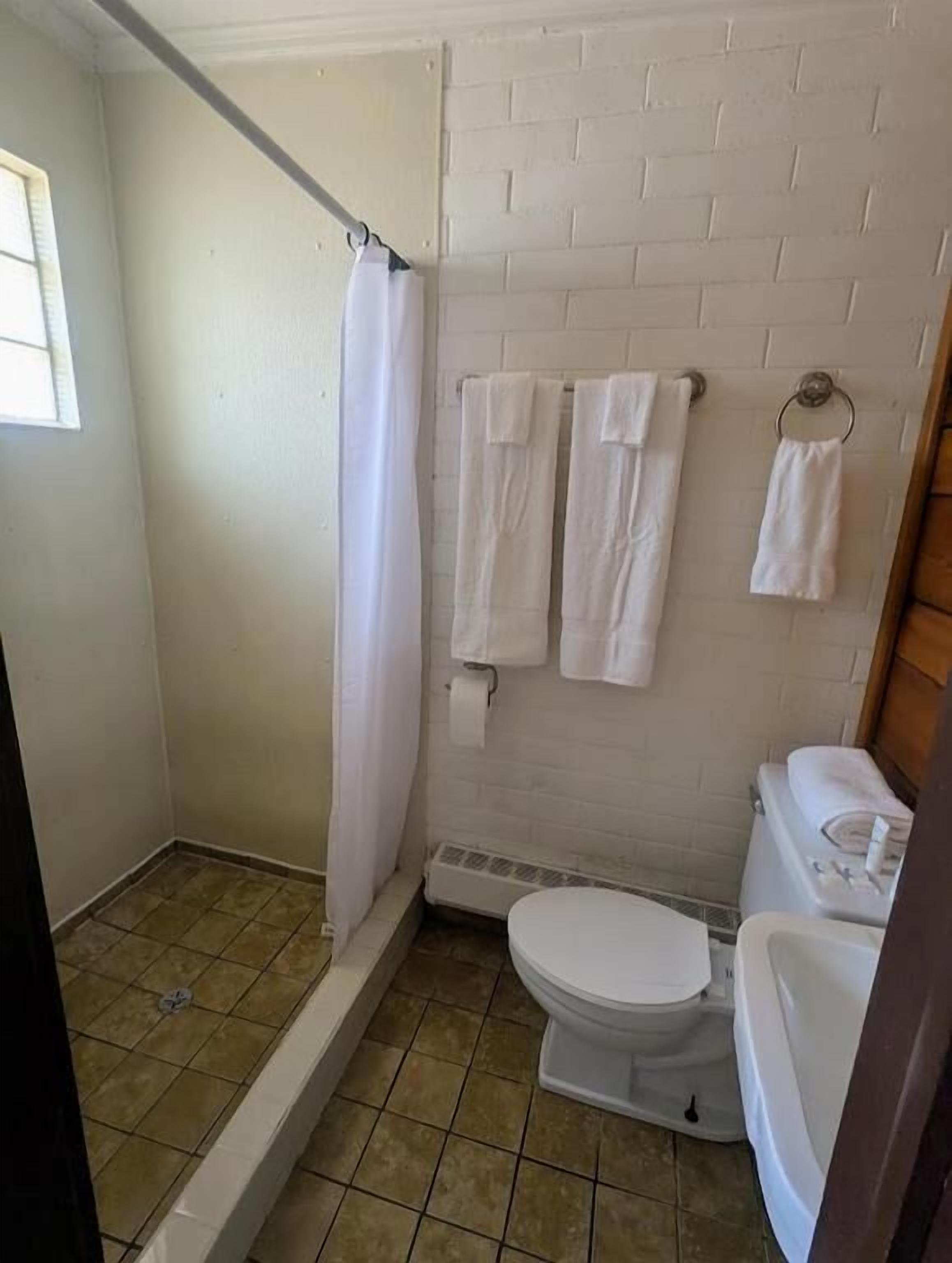Une petite salle de bain avec une douche, des toilettes et un lavabo.