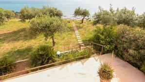 A pathway leading to a beach with a wooden fence and potted plants. - Bongiovi Houses - App. Azure - 2 min from the beach, with garden and sea view (Sicilia)