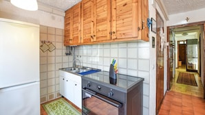 A compact kitchen with wooden cabinets, a stainless steel sink, and an oven. - 2 bedroom lovely apartment in Ponte di Legno (Ponte di Legno)