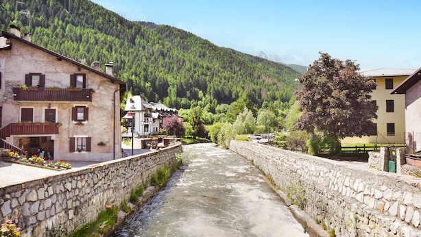 A narrow stone-lined water channel with buildings on either side, set against a backdrop of a forested mountain. - 2 bedroom lovely apartment in Ponte di Legno (Ponte di Legno)