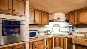 A kitchen with wooden cabinets, a stainless steel refrigerator, a microwave, and a gas stove. - Lovely home in Seravezza with WiFi (Seravezza)
