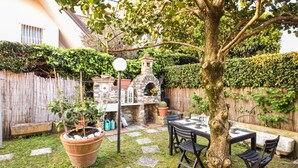A patio with stone flooring, a table, chairs, a potted plant, and a stone oven. - Lovely home in Seravezza with WiFi (Seravezza)