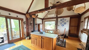 Una cocina con armarios de madera, una isla central y un comedor con sillas y una mesa.