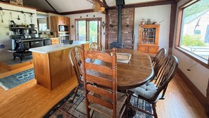 Una cocina rústica con una isla grande, sillas de madera y una mesa de comedor.